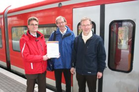Frank Josten (Sparda-Bank West) übergibt eine Urkunde mit dem Spendenbetrag an Wolfgang Hennnig (Ehrenamtlicher Zugbegleiter) und Ludger Firneburg (Geschäftsführer der Diakonie Krefeld & Viersen – Träger der Bahnhofsmission Krefeld).